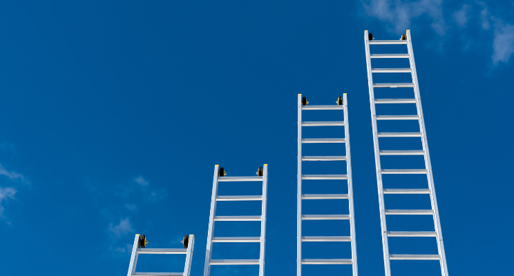 different size ladders against a blue sky