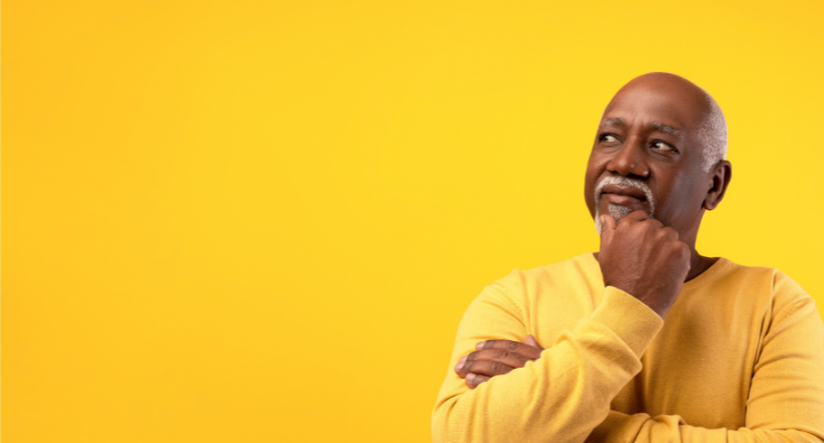 man in contemplative pose against yellow background